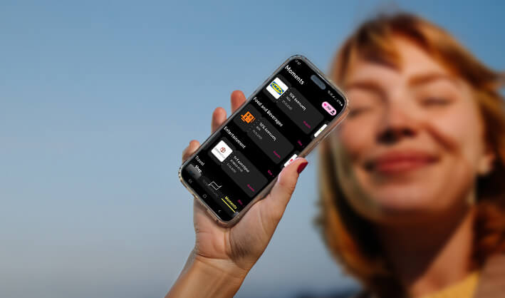 Magenta Moments. Γυναίκα κρατά smartphone με την εφαρμογή και το πρόγραμμα το νέο πρόγραμμα επιβραβεύσεων.